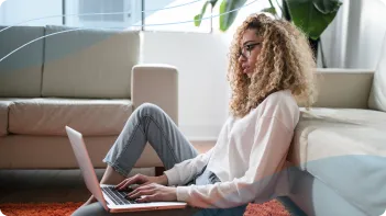 A picture of a woman typing on a laptop. Remote Neurofeedback Session.